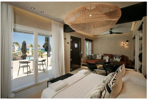a living room with a bed and a large chandelier at Eden Beachfront Residences & Suites in Kastraki Naxou