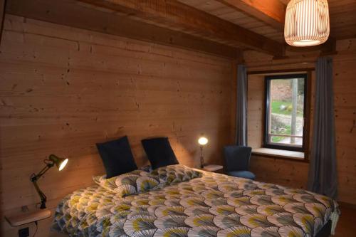 a bedroom with a bed with two chairs and a window at A la cheneau in Rochesson