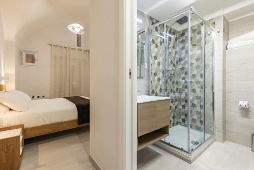 La salle de bains est pourvue d'une douche en verre et d'un lit. dans l'établissement La Torre 31, à Formia