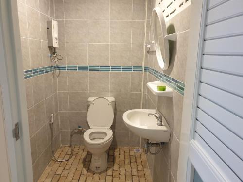 La petite salle de bains est pourvue de toilettes et d'un lavabo. dans l'établissement Rung Inn Homestay, à Ranong
