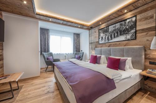 sypialnia z dużym łóżkiem i drewnianymi ścianami w obiekcie Apartment NH96 inklusive kostenfreiem Eintritt in die Alpentherme w mieście Bad Hofgastein