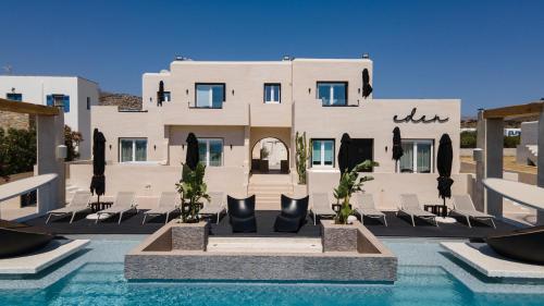 a building with a pool in front of a house at Eden Beachfront Residences & Suites in Kastraki Naxou