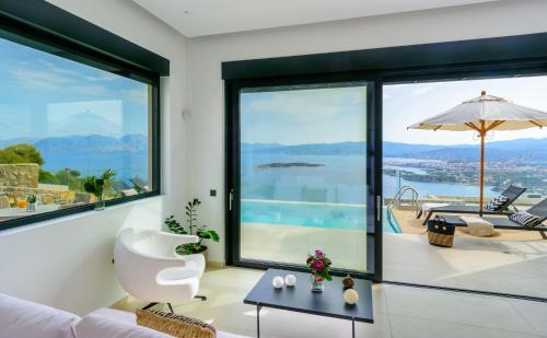 a living room with large windows and a view of the water at Majestic View Villas in Agios Nikolaos