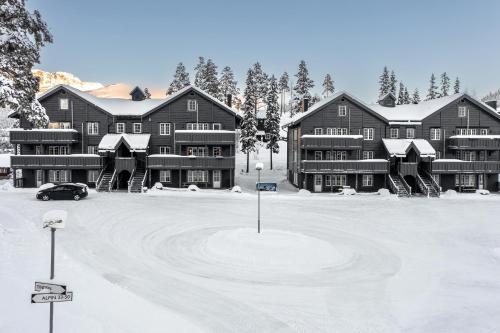 a large building in the snow with a parking lot at Tinden in Hemsedal