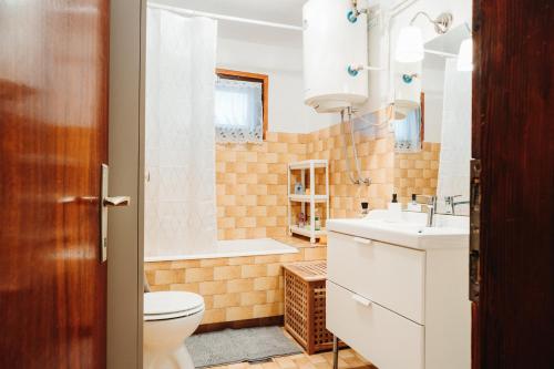 a bathroom with a toilet and a sink and a tub at Holiday House Smilja in Ogulin