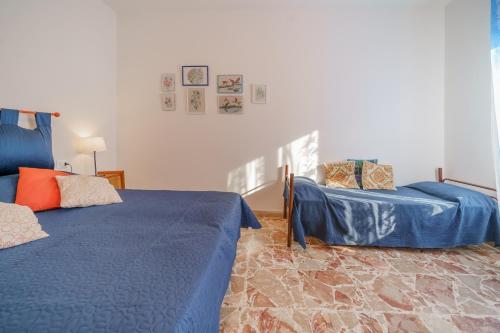 a bedroom with two blue beds and a chair at Casavacanze delle Noci in Marciana