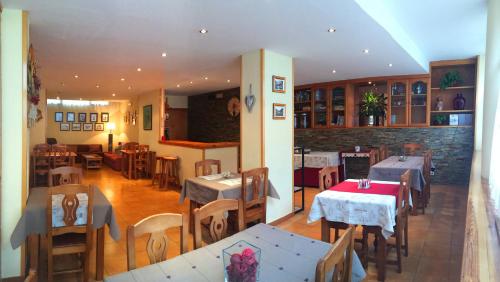 a restaurant with tables and chairs in a room at Hotel Ostau d'Òc in Vielha