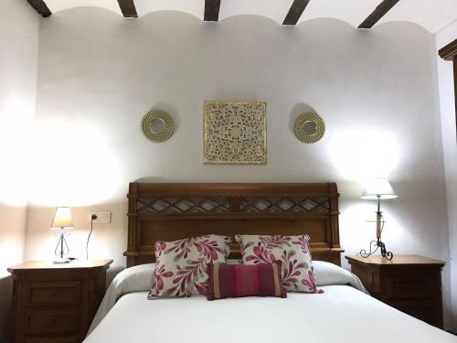 a bedroom with a white bed with two night stands and two lamps at Casa Teatro RAÍCES in Taberno
