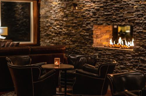 a bar with a table and chairs and a fireplace at Eriksgårdens Fjällhotell in Funäsdalen