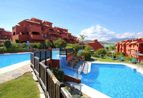 duży basen przed niektórymi budynkami w obiekcie Duplex Penthouse in Estepona- Mountain and Sea views w mieście Estepona