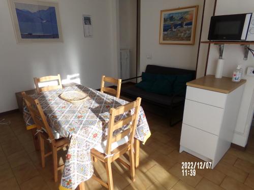 una cucina e una sala da pranzo con tavolo e sedie di Appartamento di Olga a Lecco