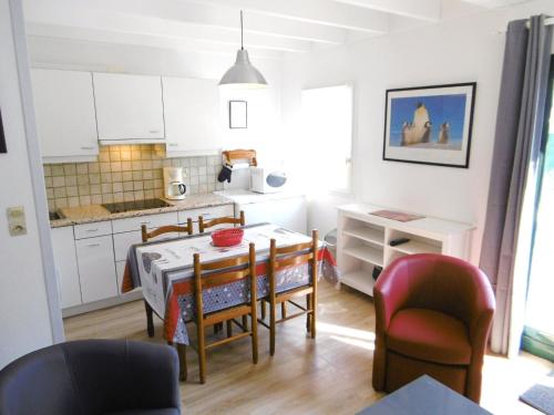 une cuisine et une salle à manger avec une table et des chaises dans l'établissement Maisonnette Katell, à Sarzeau