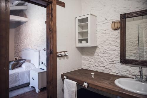 a bathroom with a sink and a mirror and a bed at Houmi A Ponte in Boimorto