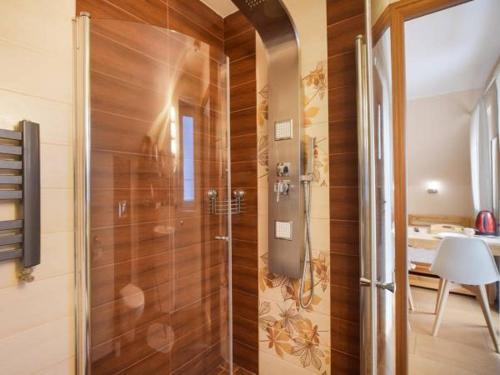 a bathroom with a shower with wooden walls at Wieczorek Pokoje Gościnne in Szczyrk