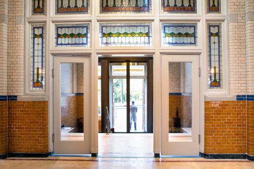 a hallway with doors and stained glass windows at Pillows Grand Boutique Hotel Maurits at the Park - Small Luxury Hotels in Amsterdam