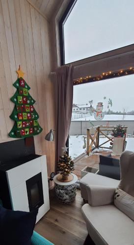 a living room with a christmas tree and a television at Domek mazurski całoroczny nad jeziorem z Sauną fińską I Jacuzzi SPA in Pasym