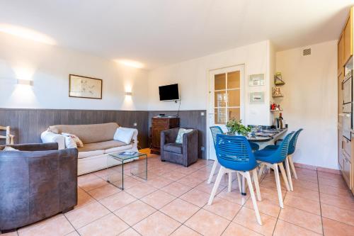 a living room with a couch and a table and chairs at Maison avec vue, idéale familles in Lacanau-Océan