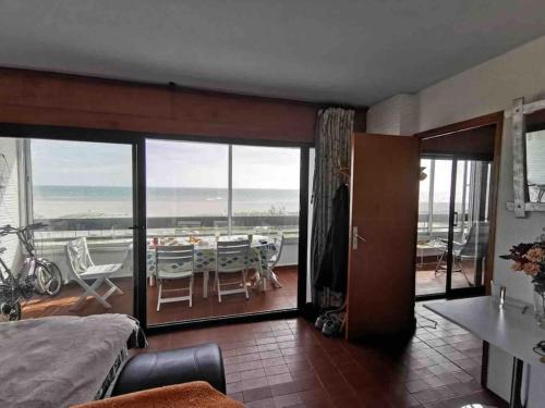 um quarto com uma varanda com uma mesa e cadeiras em Sur la plage, vue sur mer, spacieux T3 au calme em Saint-Cyprien