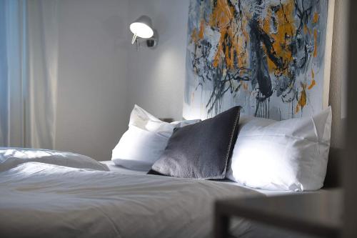 Un dormitorio con una cama con almohadas y una pintura en Gasthof Kreuz, en Bad Waldsee