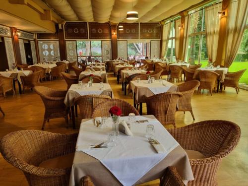 un restaurante con mesas y sillas con mantel blanco en El Oumnia Puerto & Spa, en Tánger