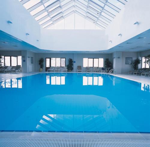 ein großer Pool mit blauem Wasser in einem Gebäude in der Unterkunft Polat Palandöken in Erzurum