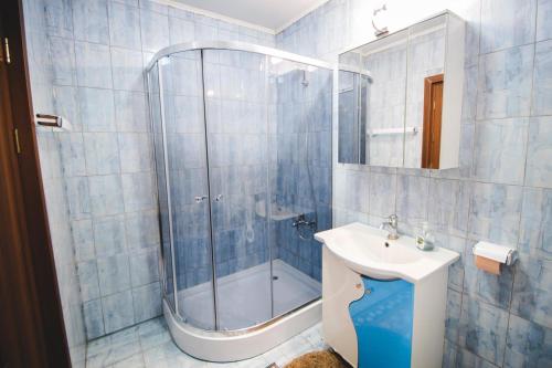 シビウにあるRelaxing residenceの青いタイル張りのバスルーム(シンク、シャワー付)