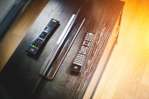 two remote controls sitting on top of a wooden couch at Relaxing residence in Sibiu