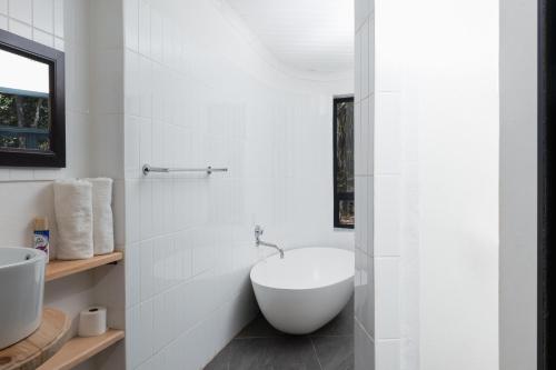 ein Badezimmer mit einer weißen Badewanne und einem Waschbecken in der Unterkunft Cederkloof Botanical Retreat in Citrusdal