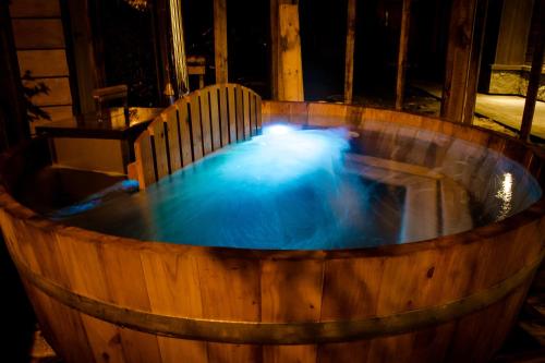 a hot tub with blue water in a wooden barrel at Cocurantu Hotel Boutique in Pucón