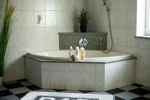 ein Bad mit einer Badewanne, einer Dusche und einem Waschbecken in der Unterkunft Ferienwohnung Tina in Breitenberg