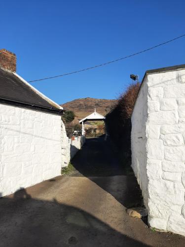 an alleyway between two white brick buildings with a house at Nellie's Farmhouse in Carlingford