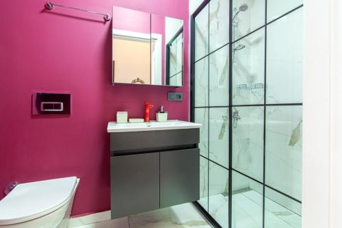 uma casa de banho com paredes cor-de-rosa, um WC e um lavatório. em Charming Flat near Kennedy Avenue in Fatih em Istambul