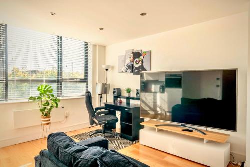 a living room with a couch and a large screen tv at Comfort Stay Apartment - Haywards Heath in Haywards Heath