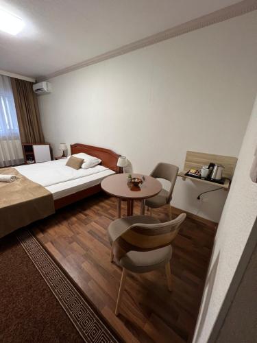 een hotelkamer met een bed en een tafel en stoelen bij HOTEL New Milenium in Lukavac