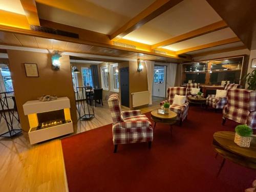 a living room with chairs and a fireplace at Berghotel Drei Brüder Höhe in Marienberg