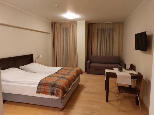 a bedroom with a bed and a chair and a table at Residence E205 Euphoria Borovets in Borovets