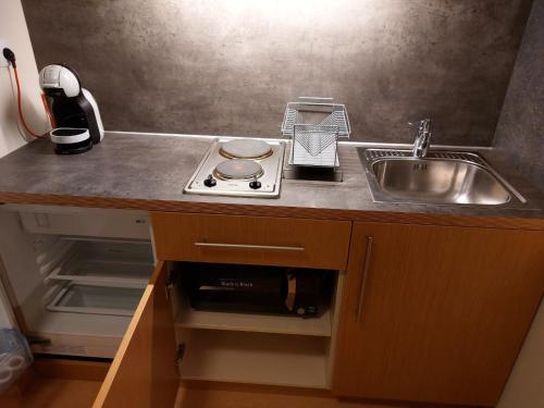 a kitchen with a sink and a stove and a counter at Residence E205 Euphoria Borovets in Borovets