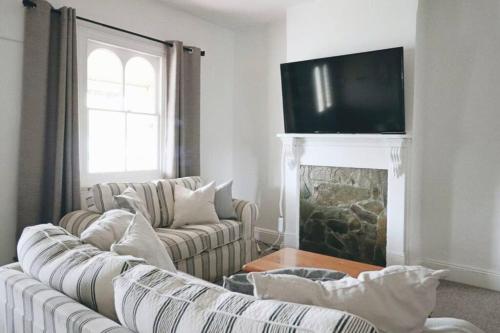 a living room with two couches and a fireplace at The Early Settler 200 metres from CBD in Bathurst