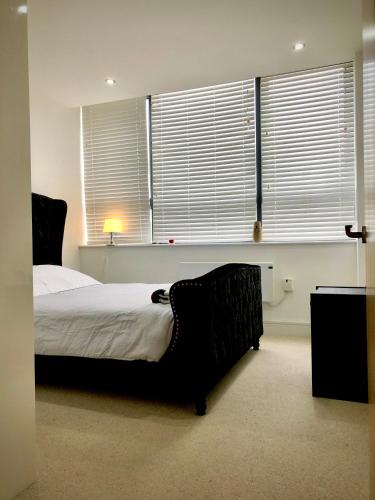 a bedroom with a bed and some windows at Serenity Suite in Haywards Heath