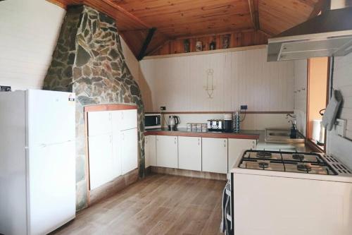 a kitchen with white cabinets and a stone wall at The Early Settler 200 metres from CBD in Bathurst