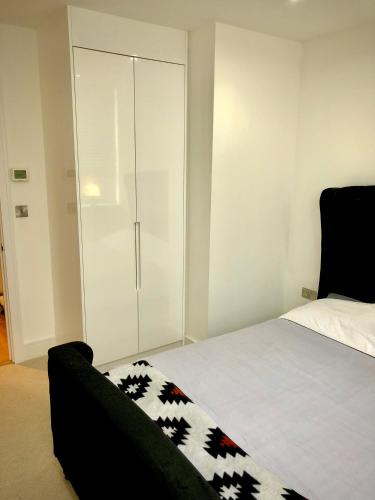 a bedroom with a bed and a glass cabinet at Serenity Suite in Haywards Heath