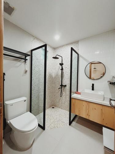 a bathroom with a toilet and a sink and a mirror at XOM House Biển Hồ in Bien Ho