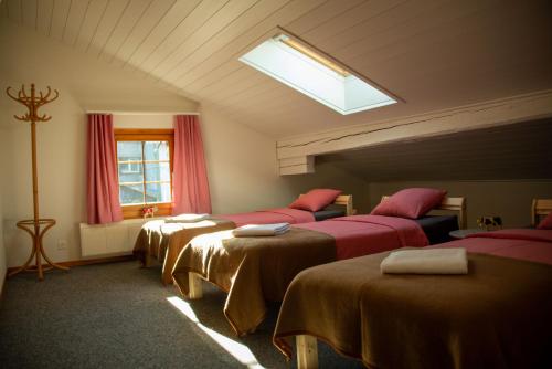 Zimmer mit 4 Betten und einem Fenster in der Unterkunft Uncle Eric's Chalet in Matten