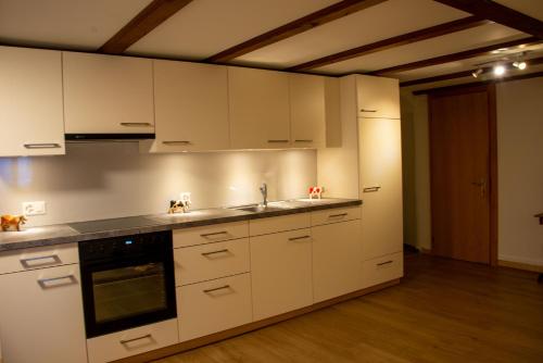 a kitchen with white cabinets and a sink at Uncle Eric's Chalet in Matten