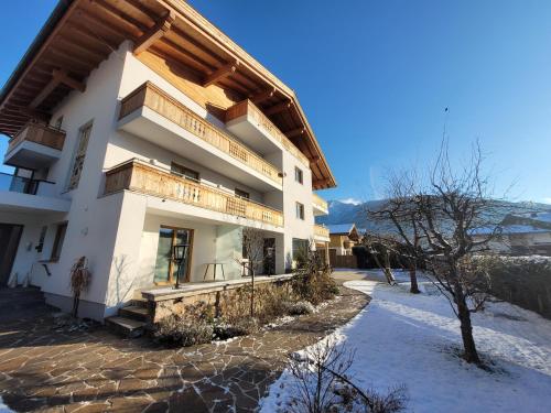 biały budynek z drewnianym dachem w obiekcie Panorama Apartments - Steinbock Lodges w mieście Zell am See
