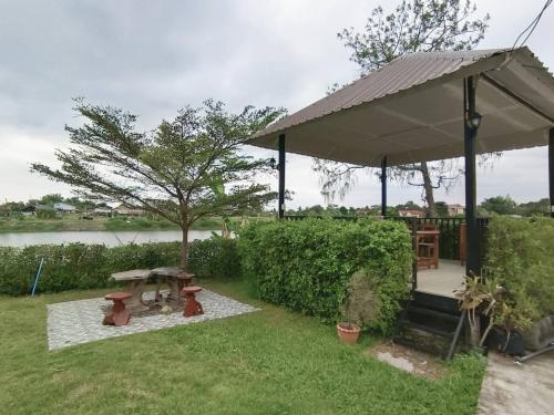 um gazebo com uma mesa de piquenique e um banco em เรือนจำปา ( Rueanjumpa resort ) em Ban Na Kai