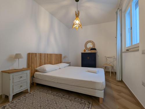 Un dormitorio con una cama y una lámpara de araña. en Appartamento Livia, en Polignano a Mare