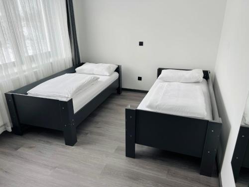two beds sitting in a room with at PARKHOTEL BRAUNAU - 24 Stunden Self Check-IN in Braunau am Inn