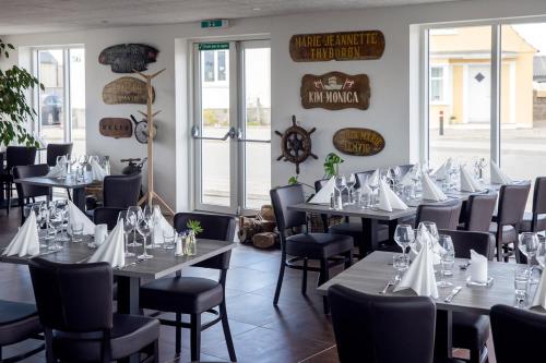 Thyborøn Hotel في Thyborøn: صف من الطاولات والكراسي في المطعم