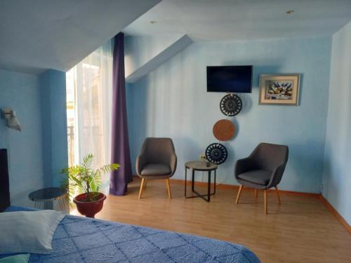 a bedroom with two chairs and a blue wall at Pensiunea Vila Dana in Cluj-Napoca